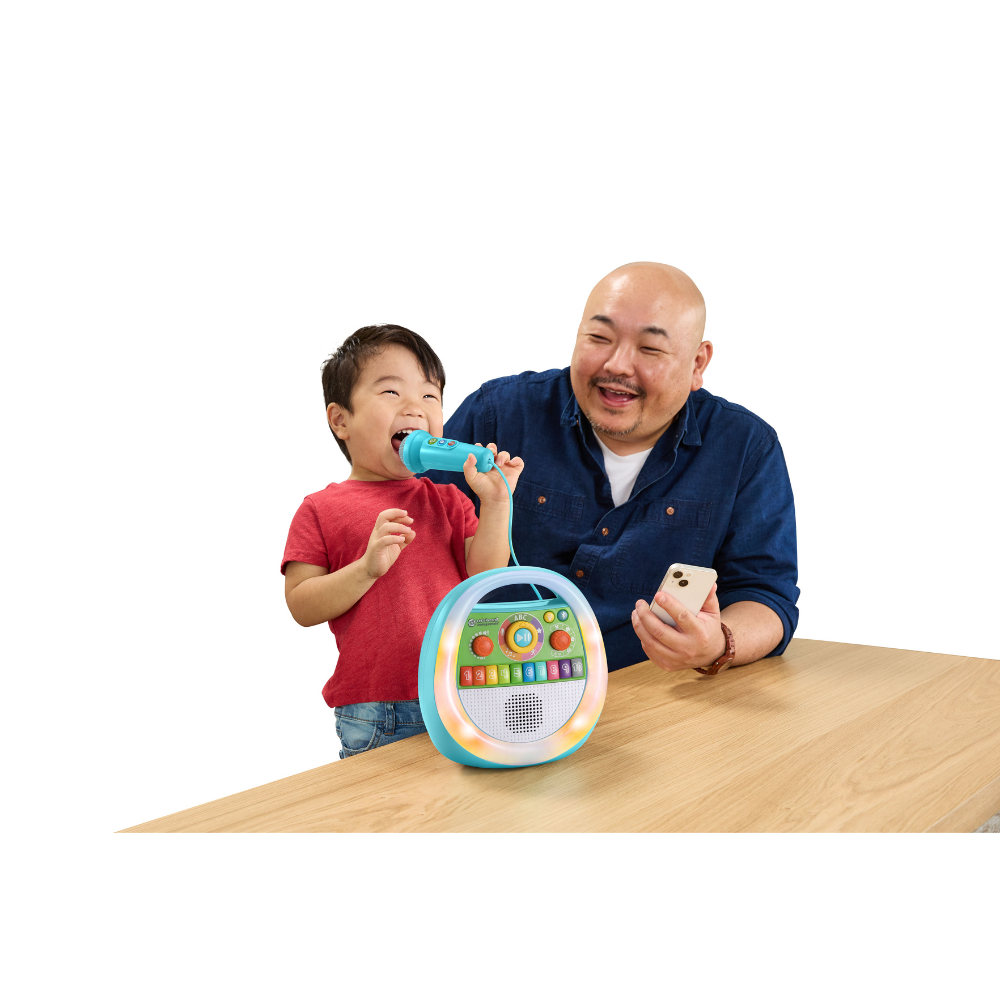 Children use a learning karaoke record toy with handheld microphone on table
