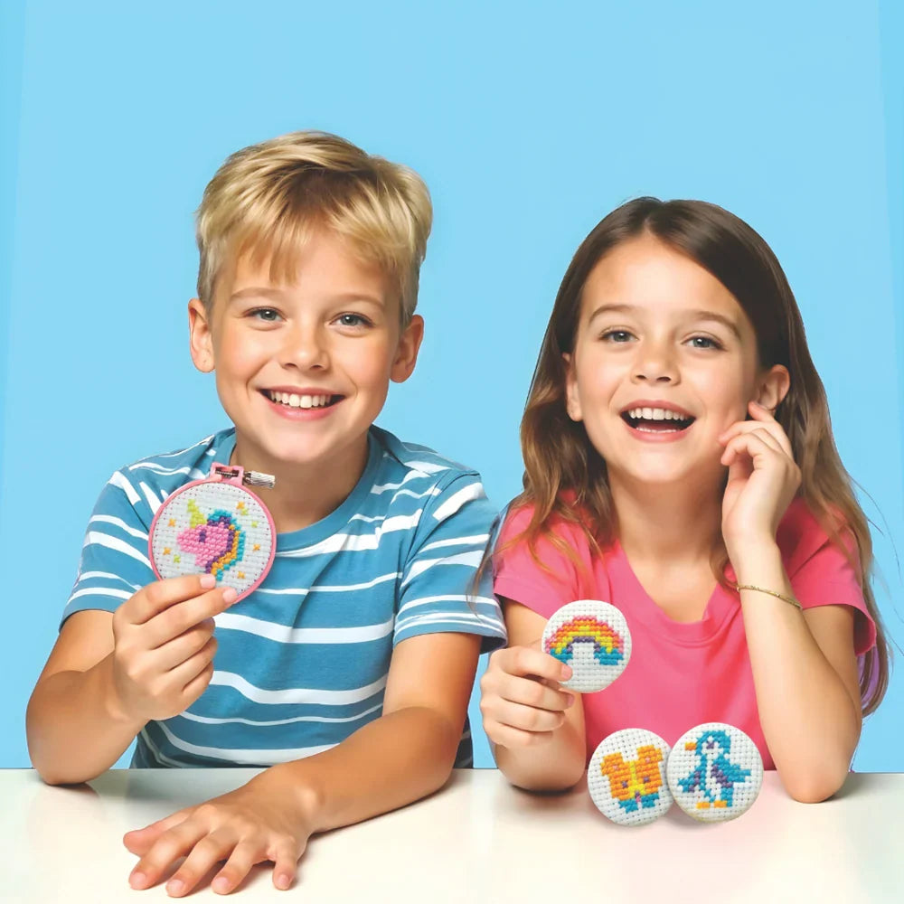 Children holding round cross-stitch button keychains with colorful pixel designs