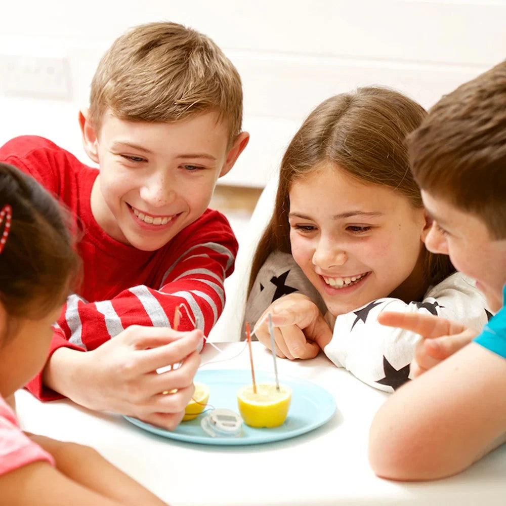 Kids playing with a STEAM science activity kit on a table, hands holding tools