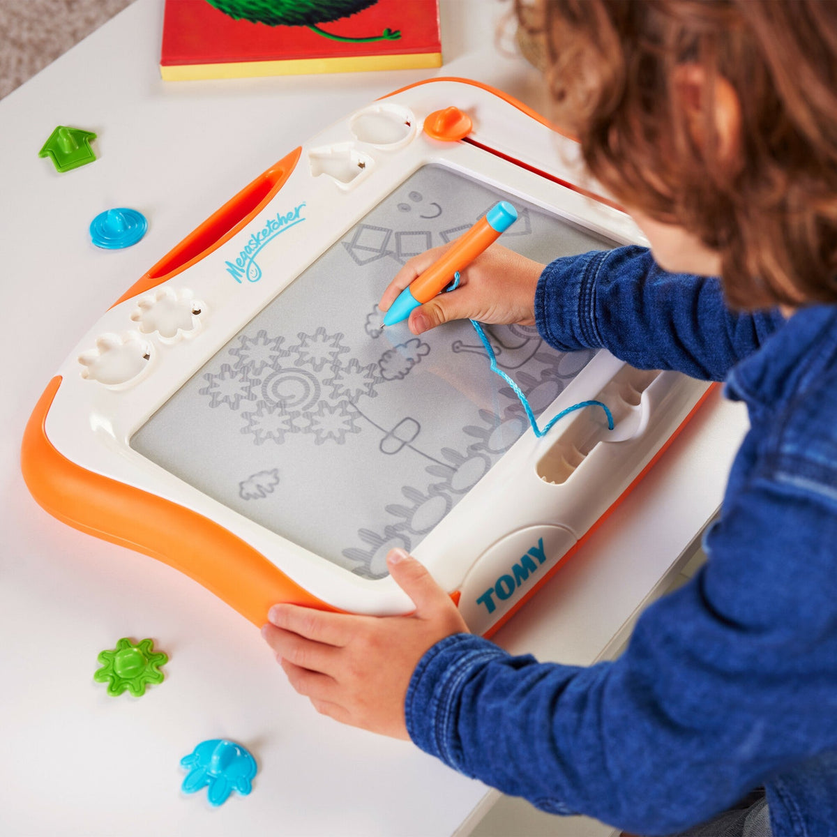 Children’s orange and white magic sketch board with stylus and colored buttons