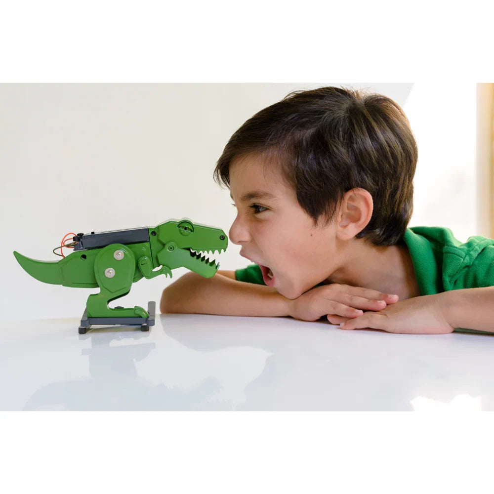 Green dinosaur-style robot toy with claw arm, child playing