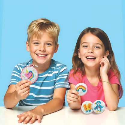 Children holding round cross-stitch button keychains with colorful pixel designs
