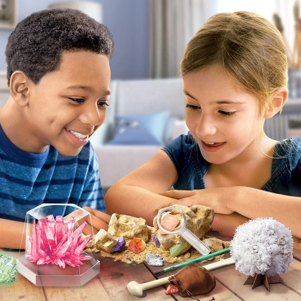 Children using science kit on table: volcano base, crystal shapes, and color tools